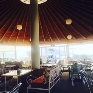 a restaurant with tables and chairs and a roof at Kompleksi Turistik EDIR in Orikum