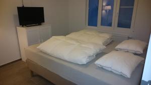 a bed with three pillows on top of it at lounge appartement zeedijk Oostende in Ostend