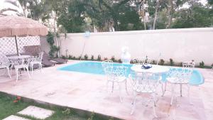 un patio con mesa y sillas junto a una piscina en Pousada Maria Bonita, en Arraial d'Ajuda