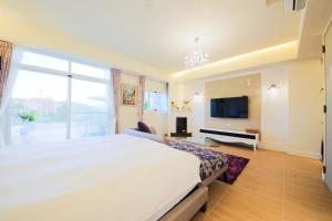 a large bedroom with a large bed and a tv at Liu Yuan Green Villa in Taitung City