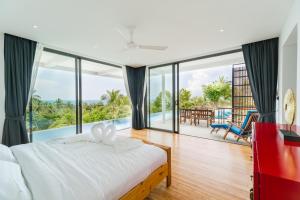 een slaapkamer met een bed en uitzicht op de oceaan bij Villa Tosti in Ban Bang Po