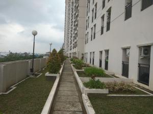 uma passagem entre dois edifícios com plantas em DSR Apartment Margonda Residence 5 em Depok