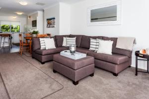 a living room with two couches and a table at Tides Reach Whitianga in Whitianga
