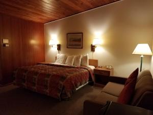 Habitación de hotel con cama y sofá en Budget Host Melody Lane en Raton