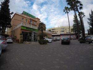 a parking lot with cars parked in front of a building at Hostal La Casa de Enfrente in Málaga