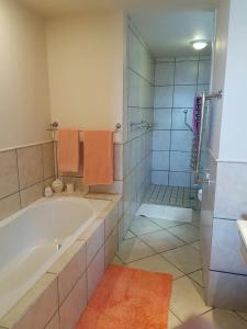 a bathroom with a bath tub and a shower at Royal Albatros in Gansbaai