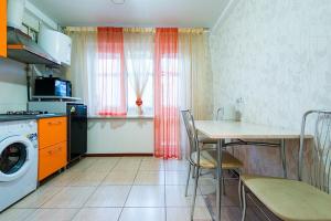 a kitchen with a table and a table and a washing machine at Studiominsk 8 Apartments in Minsk