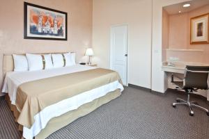 クエルナバカにあるホリデーイン クエルナバカの大きなベッドとデスクが備わるホテルルームです。