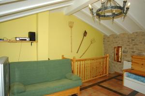 een woonkamer met een groene bank en een klok aan de muur bij Casa Cami Real in Villafranca del Cid