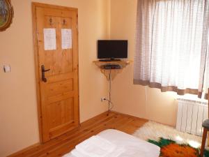 una stanza con porta e televisore in una stanza di Guesthouse Argacho a Stob