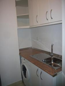 eine kleine Küche mit Spüle und Waschmaschine in der Unterkunft Ocean 3 - Fincas Arena in Benidorm
