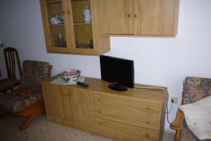 a television on a wooden dresser in a room at Ocean 3 - Fincas Arena in Benidorm