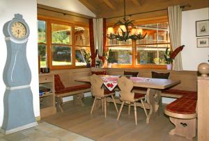 a dining room with a table and a clock at Chalet on the Lake in Hinterthal