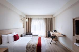 a hotel room with a bed and a desk at Oaks Bodhgaya in Bodh Gaya