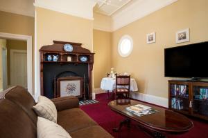 a living room with a couch and a fireplace at Loloma Bed and Breakfast in Armidale