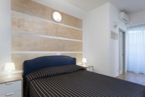 sypialnia z łóżkiem z drewnianymi akcentami w obiekcie Residenza Levante w mieście Riccione