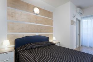 リッチョーネにあるResidenza Levanteの木製のアクセントの壁のベッドルーム1室