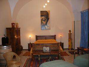 MerineにあるIl Castello te Lu Sannà B.&B.のベッドルーム1室(ベッド1台付)が備わります。壁には絵画が飾られています。