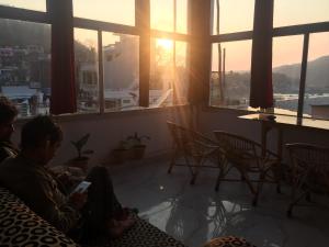 two people sitting on a couch playing a video game at BlueStays Hostel in Rishīkesh