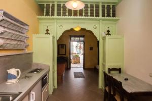 a kitchen with green cabinets and a hallway with a table at Karnayo in Meyisti