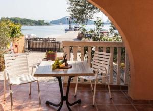 a table and chairs on a balcony with a view of the water at Apartmani Mudronja in Murter