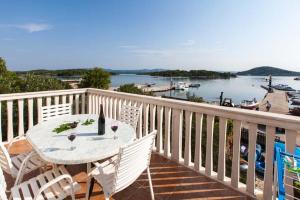 a table and chairs on a balcony with a view of the water at Apartmani Mudronja in Murter +23 photos