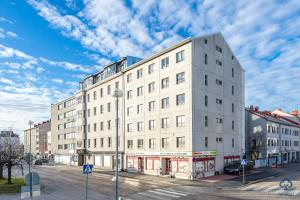 a white building on the corner of a street at Apartment Pohjanpoika in Oulu