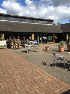 a building with tables and chairs in a courtyard at Warrington Motel, J20 M6 Lymm Services in Warrington