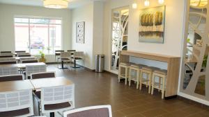 a dining room with tables and chairs and a fireplace at Microtel Inn & Suites by Wyndham - Penn Yan in Penn Yan