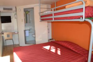 ein Schlafzimmer mit einem Etagenbett mit einer roten Tagesdecke in der Unterkunft Premiere Classe Biarritz in Biarritz