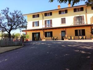 a large yellow building with chairs in front of it at Hotel La Rama in Lazise