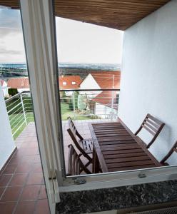 a balcony with a wooden table and chairs on it at Ferienwohnung mit Fernblick in Kohlberg