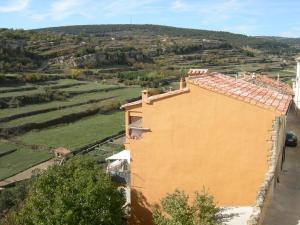 an orange building with a hill in the background at Casa Cami Real in Villafranca del Cid