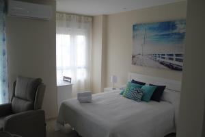 タリファにあるSan Mateo Loftのベッドルーム1室(ベッド1台、椅子、窓付)