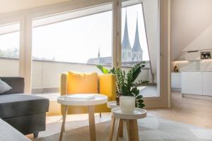 a living room with a yellow chair and a table at Top City Center Apartments location next to Lion Monument in Luzern