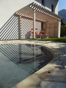 a swimming pool with a pavilion in front of a house at Hotel Garni Sirmian in Merano