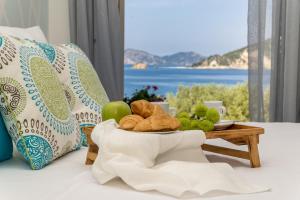 a tray of bread and fruit on a table with a window at Arba Rooms in Marathias