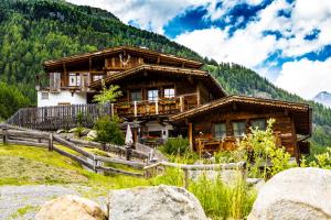 una cabaña de madera en las montañas con una valla en Grünwald Resort Sölden en Sölden