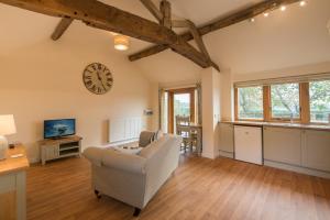 a living room with a chair and a clock on the wall at Cart Shed Cottage in Newport