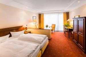 a hotel room with two beds and a desk at Hotel Villa Marburg im Park in Heigenbrücken +55 photos