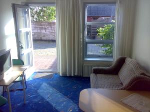 een kamer met een bank, een stoel en een raam bij Hotel Gedser Apartments in Gedser