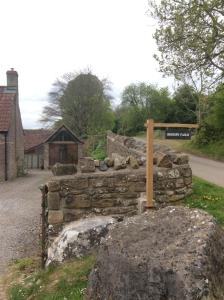 eine Steinmauer mit einem Schild darüber in der Unterkunft Bishops Farm in Thornbury