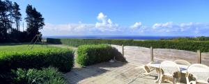 a patio with chairs and a view of the ocean at Gîtes Merour - Telgruc in Telgruc-sur-Mer