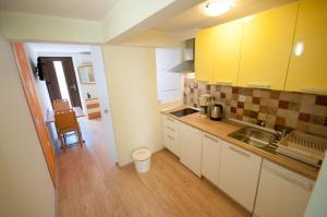 kuchnia z żółtymi szafkami i drewnianą podłogą w obiekcie Dario Apartment by the sea w mieście Novigrad