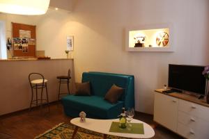 uma sala de estar com uma cadeira verde e uma televisão em Apartment Sarajevo Center em Sarajevo