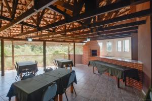 a room with tables and chairs and a fireplace at Hotel Dom Thomaz in Jaguariaíva