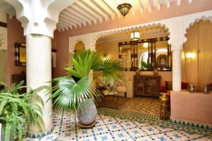 a lobby with potted plants on a tiled floor at Riad Manissa in Marrakesh