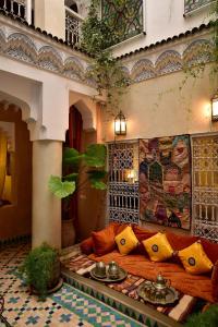 sala de estar con sofá y almohadas en Riad Manissa, en Marrakech