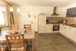 a kitchen with a table and a refrigerator at Wildnisresidenz am Nationalpark in Lindberg