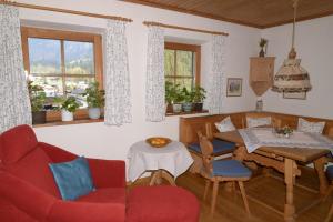 シェーナウ・アム・ケーニッヒスゼーにあるAlpenhof Punzenlehenのリビングルーム(赤いソファ、テーブル付)
